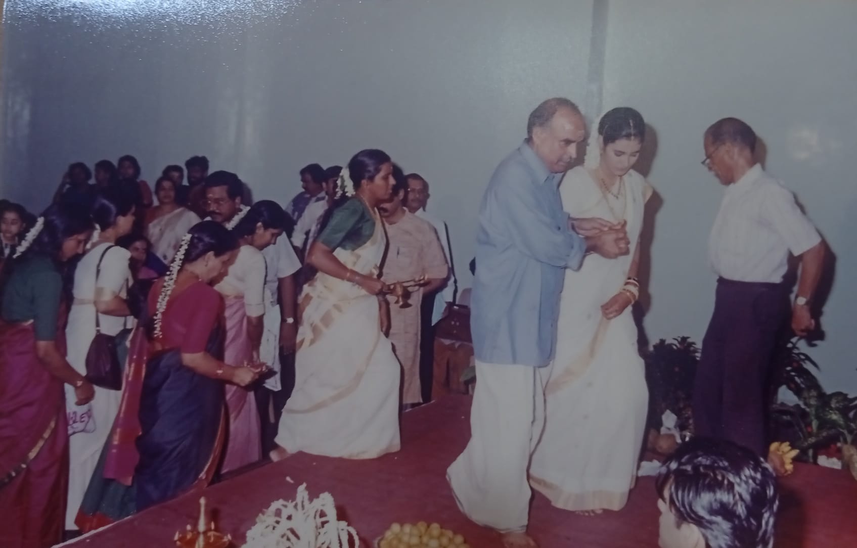 A bride being led into the hall as guests look on